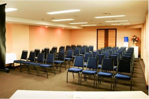 a conference room with blue chairs in a room at Tower Icaraí Hotel in Niterói