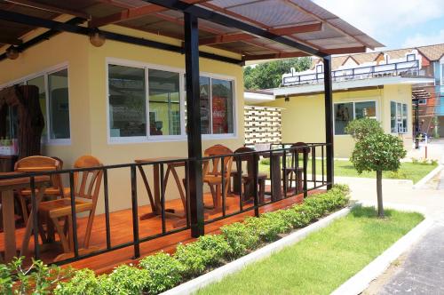 a deck with chairs and tables on a house at Chanpraya Resort in Chanthaburi