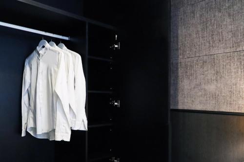 a white shirt hanging on a rack in a bathroom at Hotel NuVe Urbane in Singapore