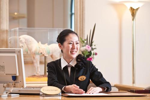 a woman sitting at a desk with a computer at Hotel Okura Tokyo Bay in Urayasu