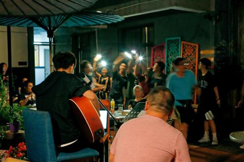 a group of people sitting in a room with a crowd of people at Kunming Upland International Youth Hostel ,near the city center ,2 mins walk to the subway, 2 mins walk to the Green Lake, Close to Yuan tong Temple, Old street, Yunnan University, convenient payment and visa cards are accepted in Kunming