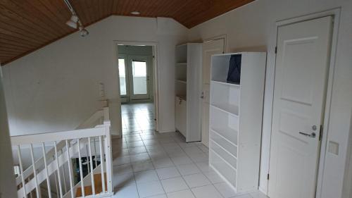 a hallway with a refrigerator and a staircase at Talvitaival Apartments in Varkaus