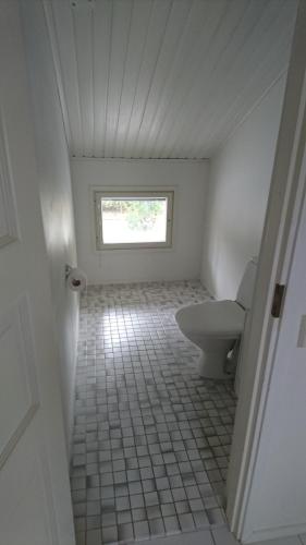 a bathroom with a toilet and a window at Talvitaival Apartments in Varkaus