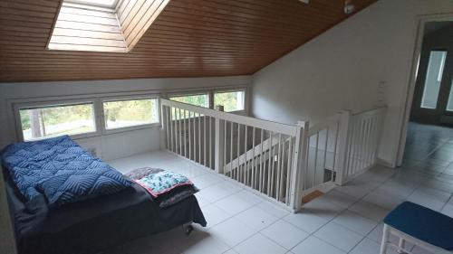 a room with a bed and a staircase with windows at Talvitaival Apartments in Varkaus