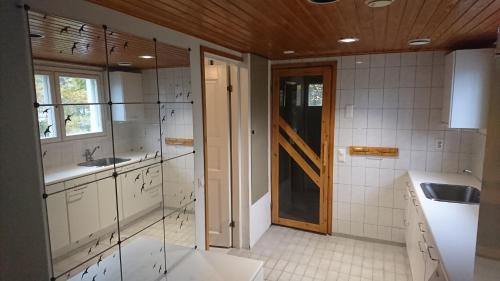 a bathroom with a sink and a glass door at Talvitaival Apartments in Varkaus