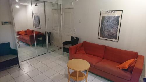 a living room with a red couch and a table at Talvitaival Apartments in Varkaus