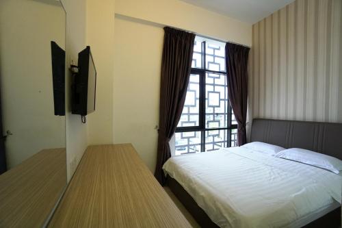 a bedroom with a bed and a tv and a window at Crystal Garden Hotel - Seri Kembangan in Seri Kembangan