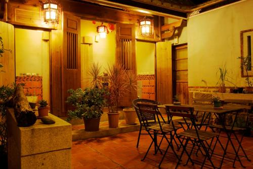 金寧鄉的住宿－鱟墅古厝民宿，配有桌椅和植物的房间