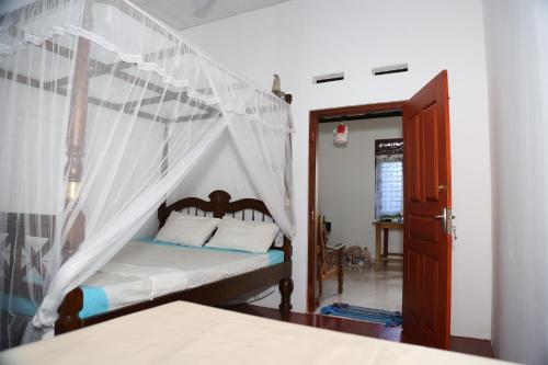 1 dormitorio con 1 cama con dosel en Sun Bird Eco Guest Mirissa, en Mirissa