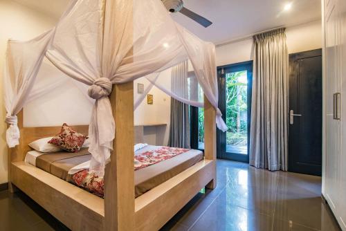una camera da letto con un letto a baldacchino di Stunning Villa Lily a Lovina