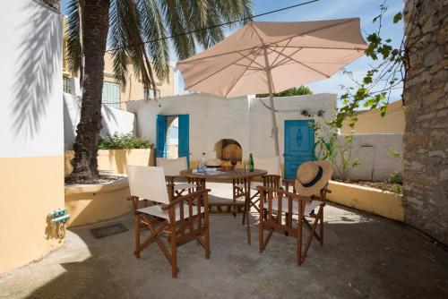 a table and chairs with an umbrella on a patio at Original Villa Petros in Symi