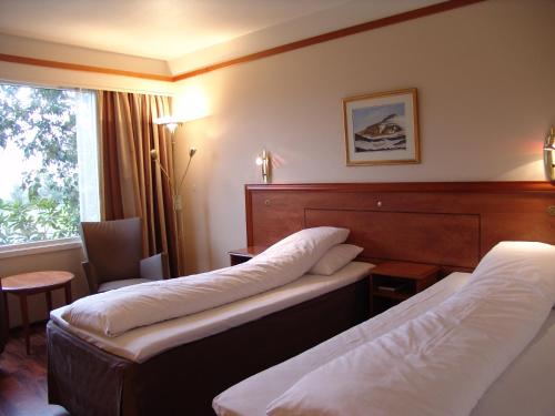 ein Hotelzimmer mit 2 Betten und einem Fenster in der Unterkunft Westland Hotel in Lindås