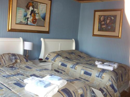 two beds sitting next to each other in a room at Auberge Le Four à Pain in Petite-Rivière-Saint-François