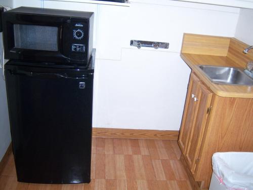 a small kitchen with a microwave on top of a refrigerator at Shasta Dam Motel in Shasta Lake