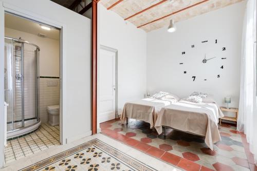 sypialnia z 2 łóżkami i zegarem na ścianie w obiekcie Monti Colosseum apartment w Rzymie
