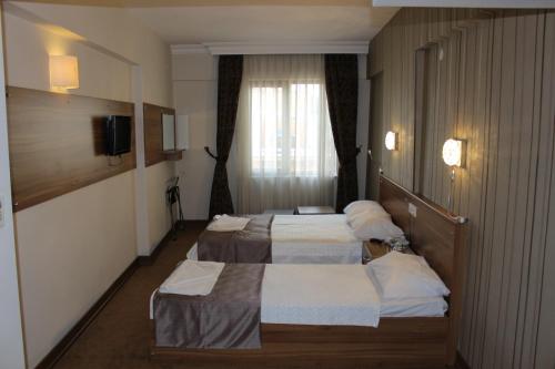 イスタンブールにあるGrand Laleli Hotelのベッド2台とテレビが備わるホテルルームです。