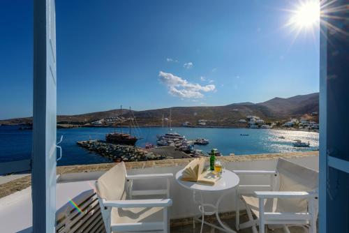 einen Tisch und Stühle auf einem Balkon mit Blick auf das Wasser in der Unterkunft Vardia Bay Studios in Karavostasi