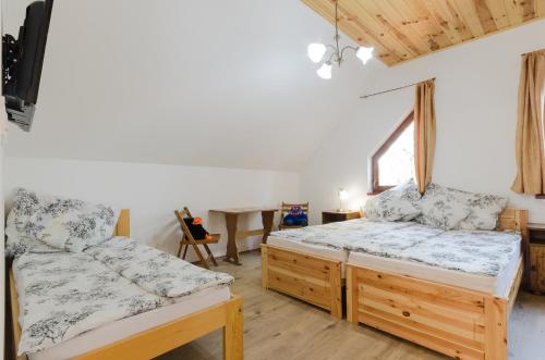 a bedroom with two beds and a desk at Árnyas Vendégház Egerszalók in Egerszalók