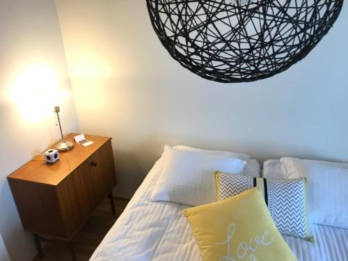 a bedroom with a bed and a table with a lamp at The Harbour Apartments in Jyväskylä