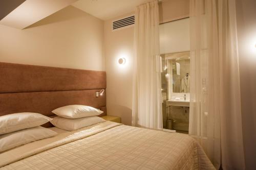 sypialnia z łóżkiem z białymi poduszkami i oknem w obiekcie Gorka Hotel w mieście Aksin'ino