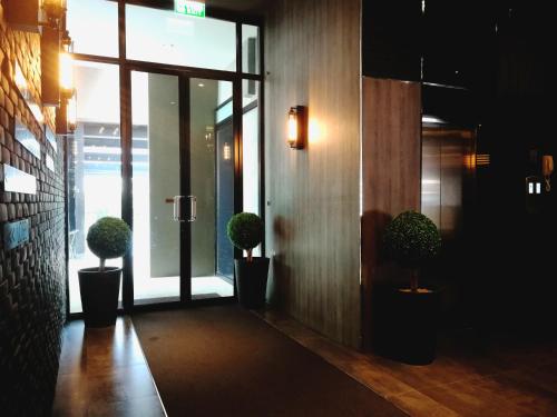 a hallway with three potted plants in a building at S Hadyai Hotel in Hat Yai
