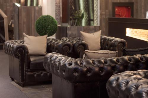 a leather couch and a chair in a room at S Hadyai Hotel in Hat Yai