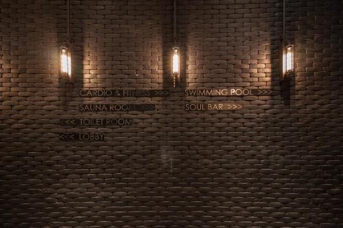 a brick wall with lights and a swimming pool sign at S Hadyai Hotel in Hat Yai