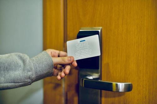 a person is holding up a card to a door at SAHIL Hostel & Hotel in Baku