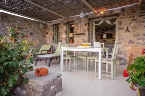 a patio with a white table and chairs in a building at Serifos Dream Houses near the sea in Ganema
