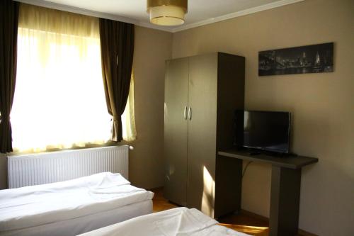 Cette chambre comprend deux lits et une télévision. dans l'établissement Guest House Central, à Kardjali