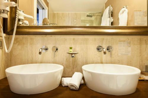 a bathroom with a large white tub and a mirror at Hotel Milano Scala in Milan