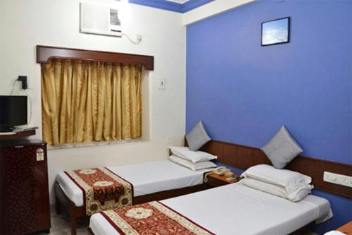 ムンバイにあるHotel Mogul Palace - Near CST Stationのベッド2台とテレビが備わるホテルルームです。