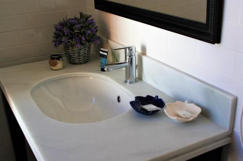 a sink in a bathroom with a mirror and flowers at nüa cicerone in Seville