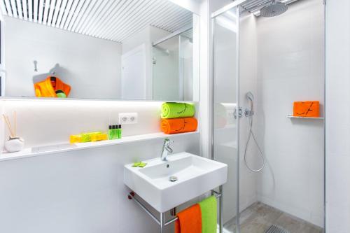 a white bathroom with a sink and a shower at Cosmo Apartments Marina – Auditori in Barcelona