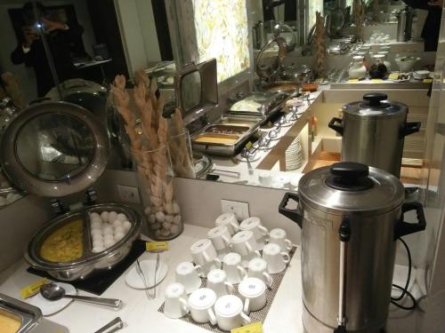 uma cozinha com uma bancada com uma panela de comida em The Shalimar Hotel, Kemps Corner em Mumbai