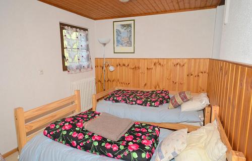 LʼHuezにあるOdalys Chalet Alpenvueのベッドルーム1室(ベッド2台、窓付)
