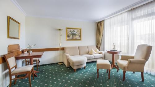 a living room with a couch and a table at Hotel Schweizer Hof Thermal und Vital Resort in Bad Füssing