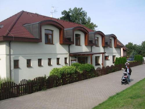 un niño montando un scooter delante de una casa en Pension U Labe, en Hradec Králové