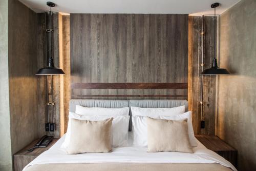 a bedroom with a white bed with two pillows at S Hadyai Hotel in Hat Yai