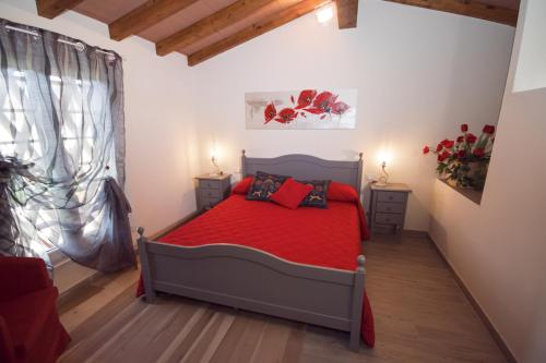 a bedroom with a red bed and a window at Il Tremarino in Camaiore