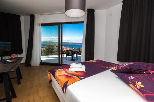 a bedroom with a bed and a view of the ocean at Pansion Preza in Selce
