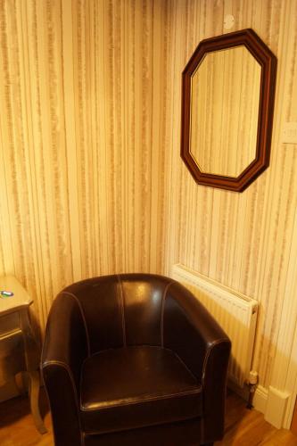 a leather chair in a room with a mirror at Marie's Bed and Breakfast in Coolock
