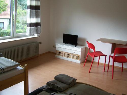 a living room with a tv and a table and chairs at Hostel Wendt in Fintel