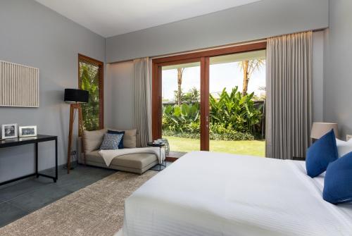 a bedroom with a large white bed and a window at Amarin Seminyak in Seminyak
