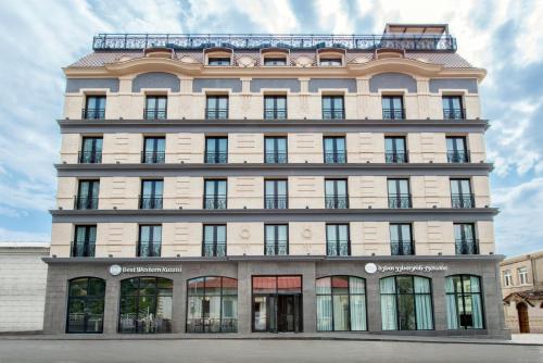 a tall white building with a lot of windows at Best Western Kutaisi City Center in Kutaisi
