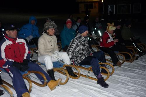 a group of people riding on a sleigh in the snow at Sport Garni Kapplerhof – Ischgl/Kappl in Kappl