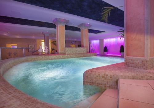 a large swimming pool in a hotel room at Hotel Schweizer Hof Thermal und Vital Resort in Bad Füssing