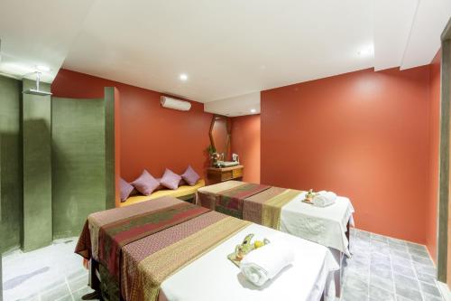 two beds in a room with red walls at Golden Temple Boutique in Siem Reap
