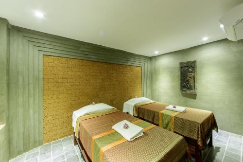 two beds in a room with green walls at Golden Temple Boutique in Siem Reap