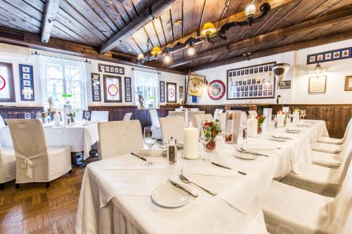 a row of tables in a restaurant with white table linens at Familie Hopfeld - Hotel Dreikönigshof in Stockerau